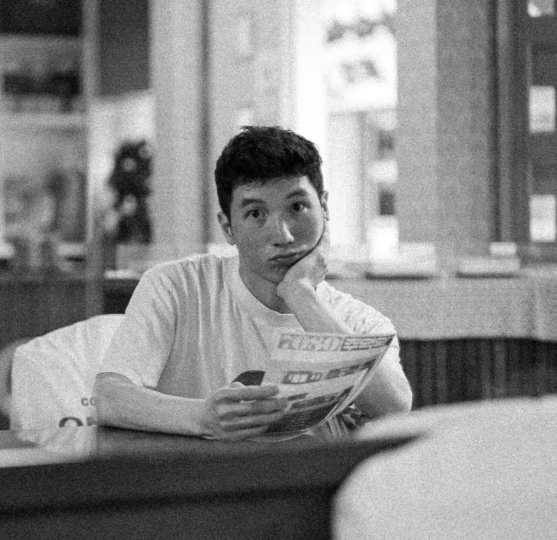 Black-and-white portrait of a person reading at a table